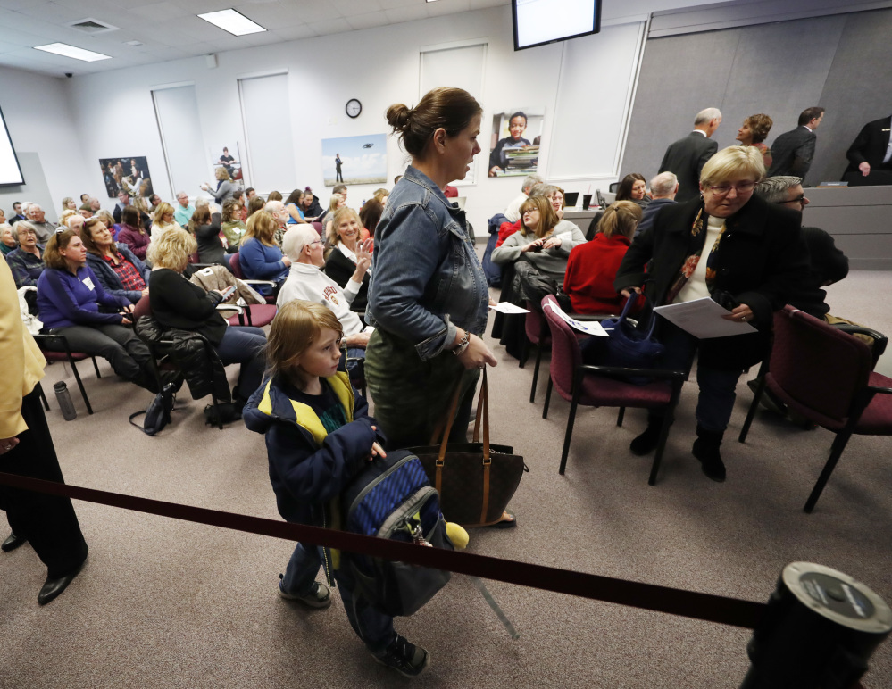 Residents filter into a hearing room to attend the Douglas County School Board meeting, Monday, Dec. 4, 2017, in Castle Rock, Colo. A new anti-voucher majority on the board was set to eliminate a program enacted by an earlier conservative-dominated board to help public school students attend secular and religious schools with taxpayer-funded vouchers. (AP Photo/David Zalubowski)