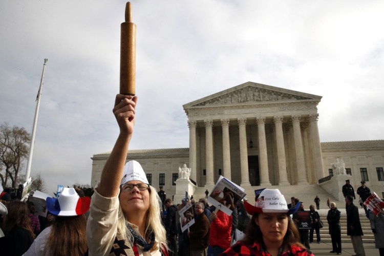 A demonstrator outside the U.S. Supreme Court Tuesday holds up a rolling pin in support of baker Jack Phillips during arguments in the case of Masterpiece Cakeshop vs. Colorado Civil Rights Commission, also known as the wedding cake case.