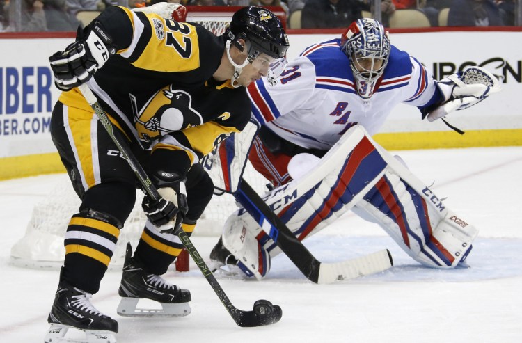 Pittsburgh's Sidney Crosby works to get off a shot in front of Rangers goalie Ondrej Pavelec during New York's 4-3 win Tuesday. Crosby was held off the scoresheet, ending a run of five straight multipoint games.