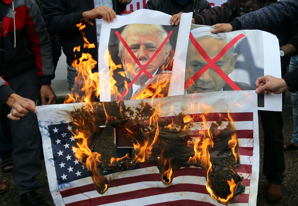 Palestinians in Rafah in the southern Gaza Strip burn posters Wednesday of Israeli Prime Minister Benjamin Netanyahu and U.S. President Trump at a protest of the U.S. intention to move its embassy to Jerusalem and to recognize that city as the capital of Israel.