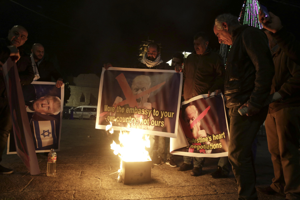 Palestinian burn a poster of the U.S. President Donald Trump during a protest in Bethlehem, West Bank, Tuesday, Dec. 6, 2017. President Trump forged ahead Tuesday with plans to recognize Jerusalem as Israel's capital despite intense Arab, Muslim and European opposition to a move that would upend decades of U.S. policy and risk potentially violent protests. (AP Photo/Mahmoud Illean)