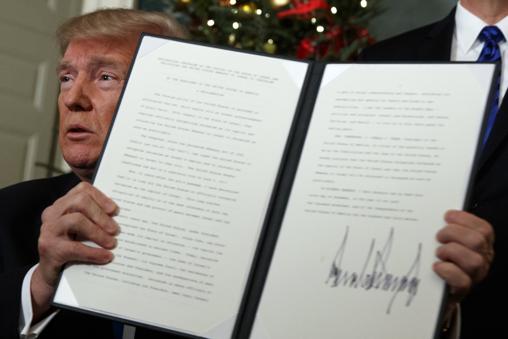 President Trump holds up his signed proclamation officially recognizing Jerusalem as the capital of Israel on Wednesday in the Diplomatic Reception Room of the White House.