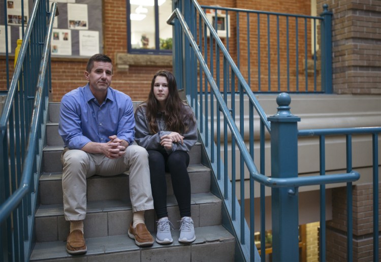 Greg Payne and his daughter Georgianna, 14, sit Thursday outside Portland High School, where she is a freshman. Years ago, when they lived in Massachusetts, a law on testing for lead spared her from severe damage.