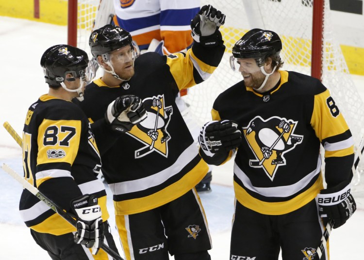Pittsburgh's Phil Kessel celebrates his goal with Sidney Crosby, 87, and Patric Hornqvist, 72, in the third period Thursday night against the Islanders in Pittsburgh.