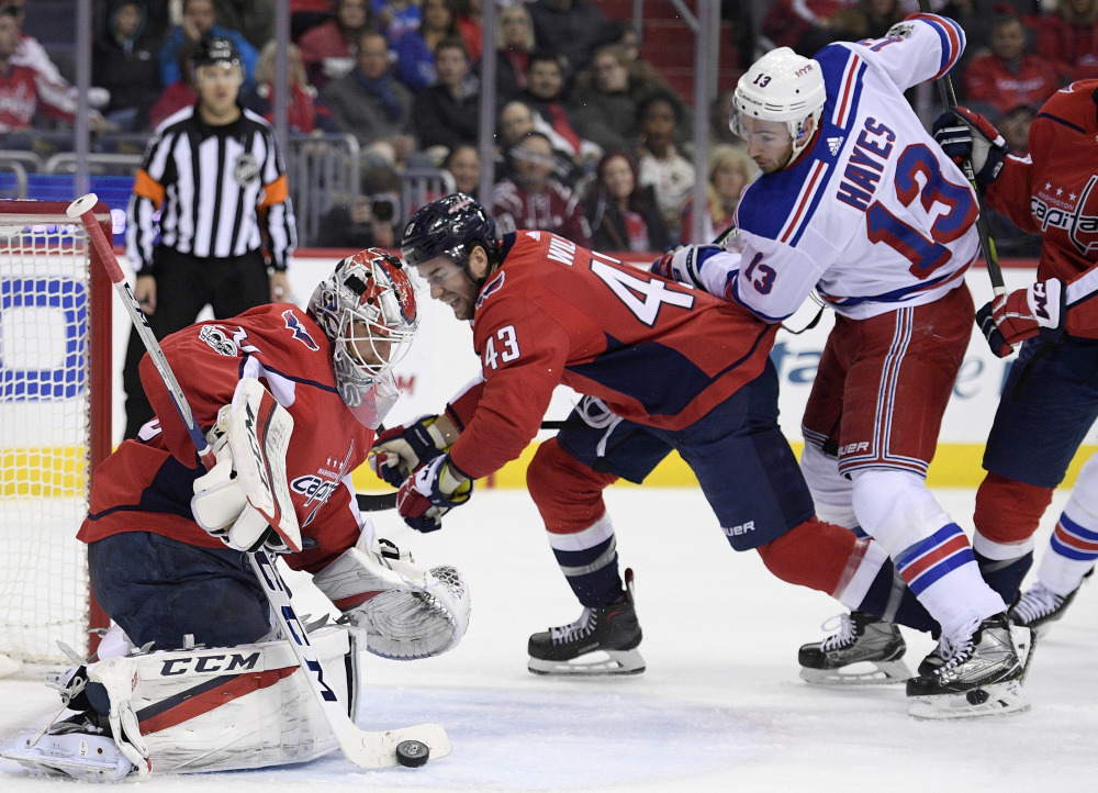 Capitals goalie Braden Holtby stops the puck as Rangers center Kevin Hayes watches during the second period Friday night in Washington, D.C. Between them is Capitals right wing Tom Wilson.