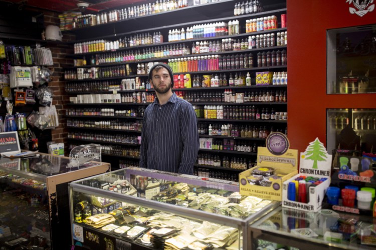 Ryan Purington, an employee at Lucky Juju in Portland, works behind the counter at the shop Thursday. The store started stocking vaporizers last month and Purington said they are "flying off" the shelves because they are discreet, easy to use and powerful.