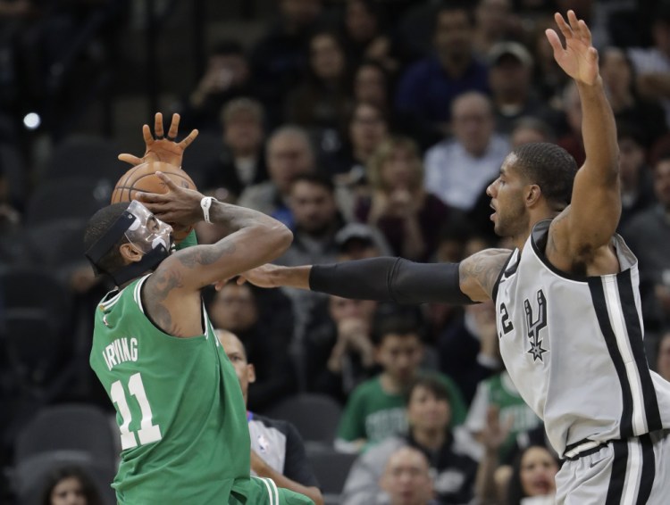 Celtics guard Kyrie Irving is fouled by San Antonio's LaMarcus Aldridge in the first half Friday night in San Antonio.