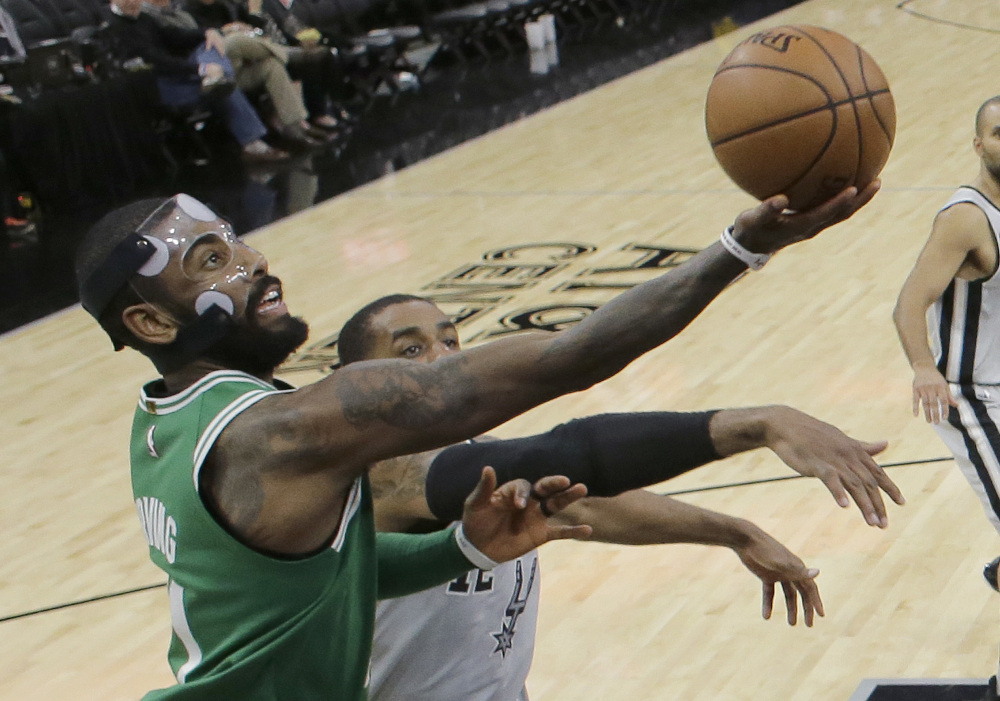 Boston's Kyrie Irving takes a shot while being defended by San Antonio's LaMarcus Aldridge on Friday in San Antonio. Irving had 36 points but missed a 3-pointer at the buzzer and the Celtics lost 105-102.