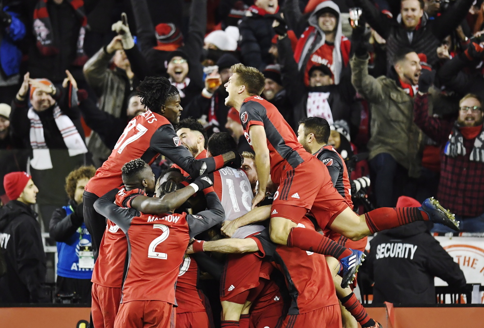Toronto FC players celebrate their second goal against the Seattle Sounders in the final minutes of the MLS Cup final in Toronto on Saturday. Toronto FC won the title, 2-0.