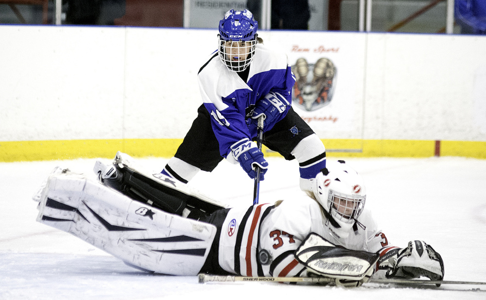 Scarborough goalie Grace Carriero makes a diving save on a shot in front of Lewiston's Sara Roberts during a girls' hockey game Saturday in Lewiston. The Blue Devils remained undefeated with a 6-1 win.
