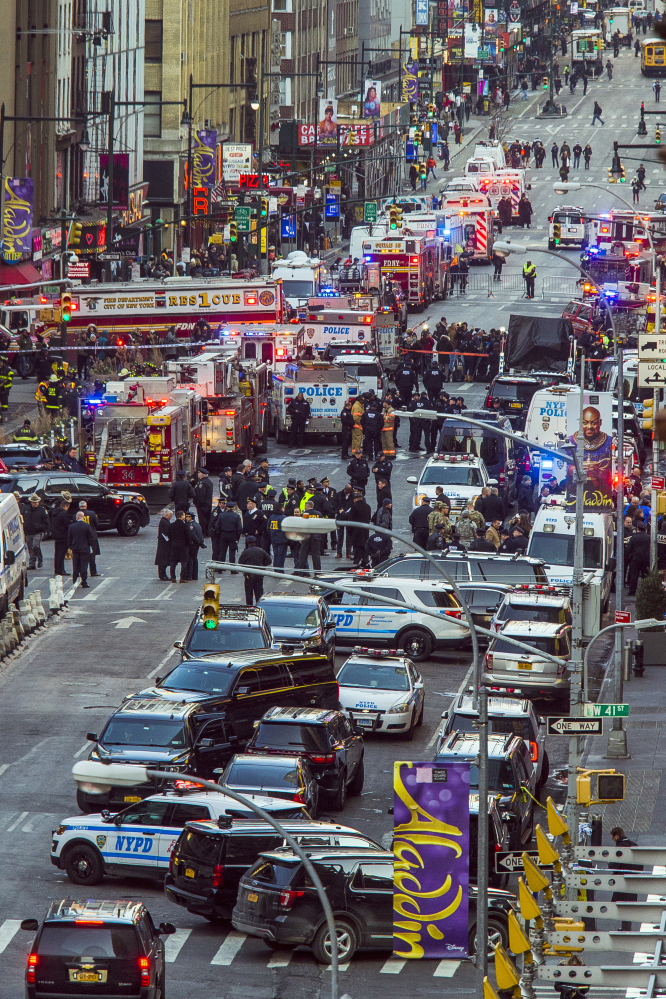 Law enforcement officials gather near New York's Times Square on Monday after a man with a pipe bomb strapped to him set off a crude bomb in an underground passageway of the subway system under 42nd Street. No one was injured except the would-be suicide bomber.