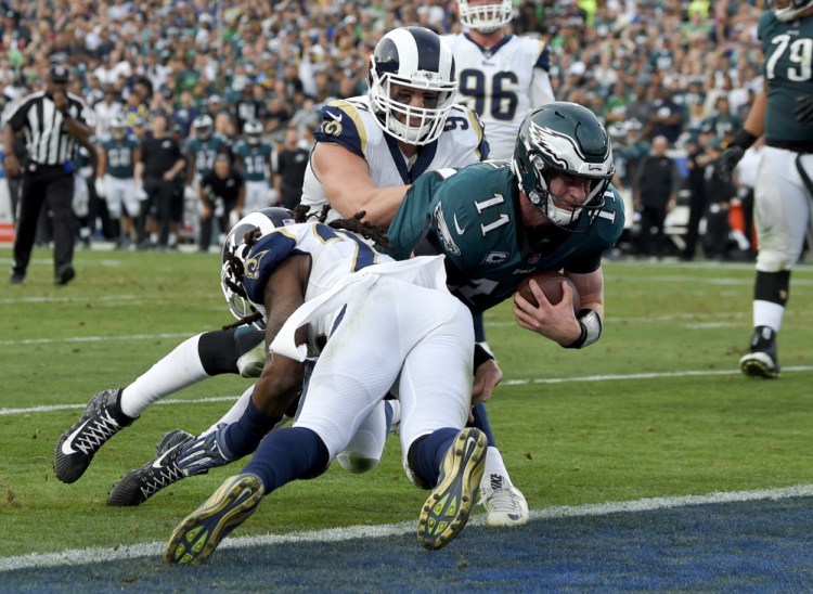 Philadelphia quarterback Carson Wentz is tackled during the second half against the Los Angeles Rams on Sunday. Wentz tore his left ACL and will miss the rest of this season and the playoffs.