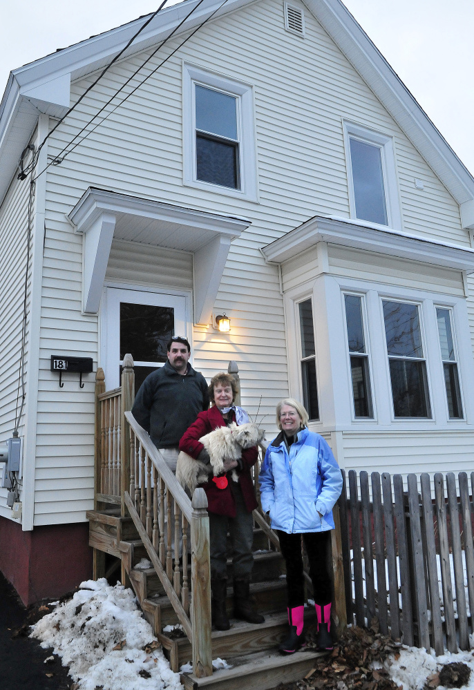 Waterville Community Land Trust members Scott McAdoo, Francis Williams and Ann Beverage at a home the organization bought and is selling at 181 Water St. in Waterville on Monday.