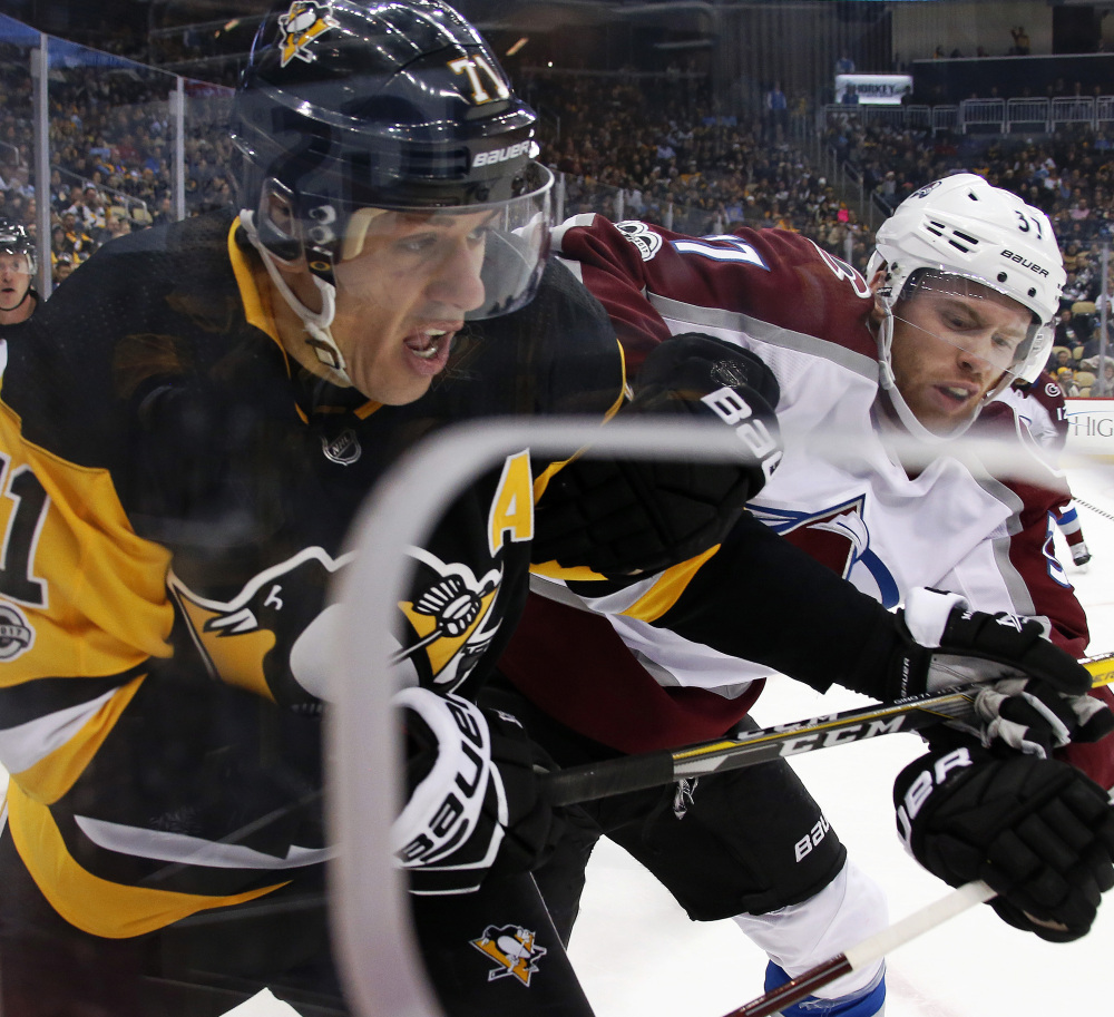 Evgeni Malkin, left, of the Penguins and J.T. Compher of the Avalanche battle for the puck during Colorado's 2-1 victory Monday night in Pittsburgh.