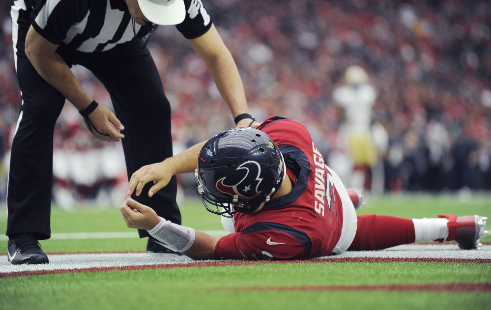 Texans quarterback Tom Savage is checked by a referee after he was hit Sunday during a game against the San Francisco 49ers. The NFL will review whether the Texans followed the concussion protocol properly.