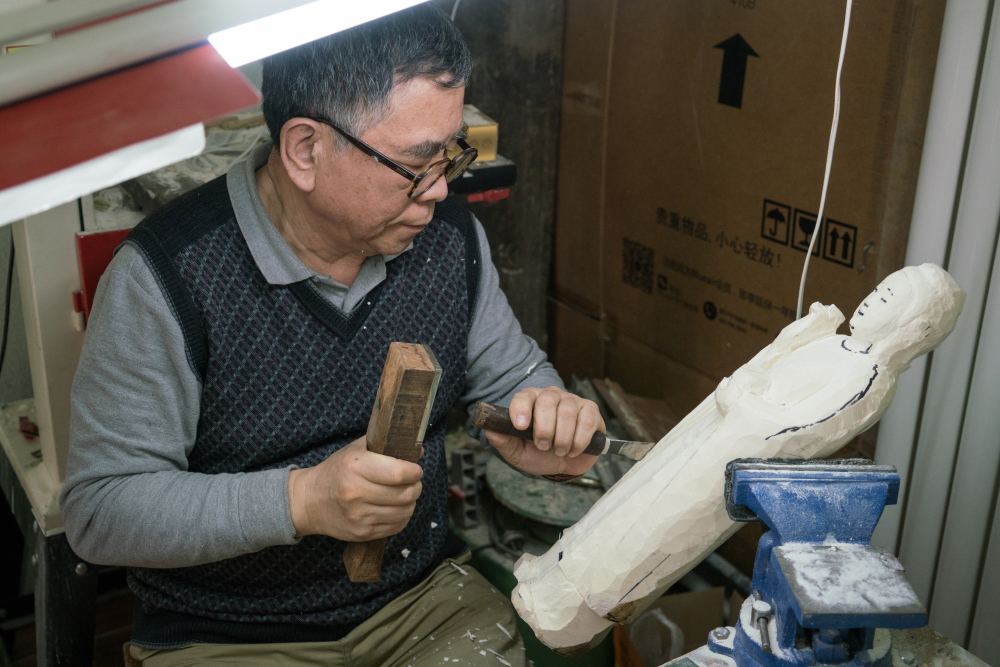 Carving artist Li Chunke works on an ivory Gautama Buddha statue in his Beijing workshop. He's worried his profession will start to die out because of China's ban on ivory sales.