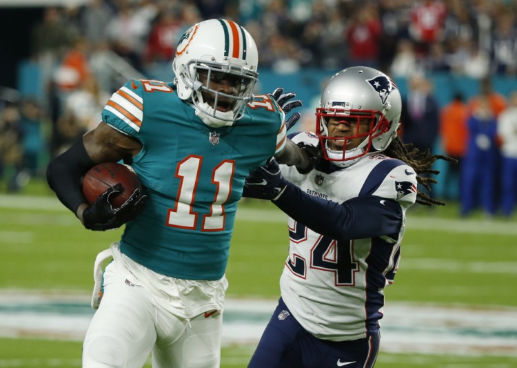 New England Patriots cornerback Stephon Gilmore (24) attempts to tackle Miami Dolphins wide receiver DeVante Parker (11), during the first half of an NFL football game, Monday, Dec. 11, 2017, in Miami Gardens, Fla. ()