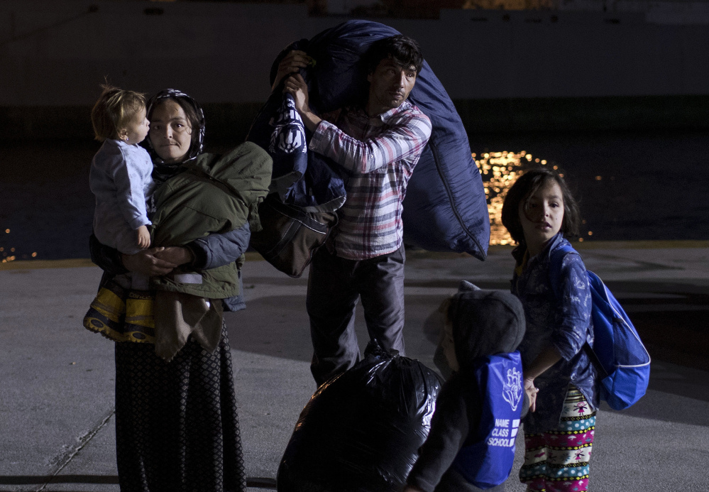 An Afghan family arrives aftyer taking a Greek ferry at the port of Piraeus near Athens early Wednesday.