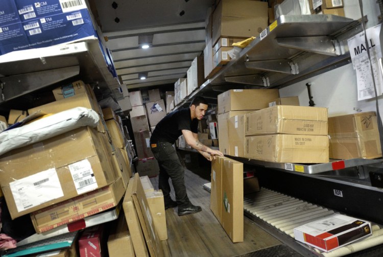 A UPS employee loads packages onto a truck at a company facility in New York in this May file photo. With Christmas on a Monday, most retailers have one less day to get packages delivered on time. UPS said earlier in December that some package deliveries were being delayed because of a surge of orders from online shoppers after Thanksgiving.