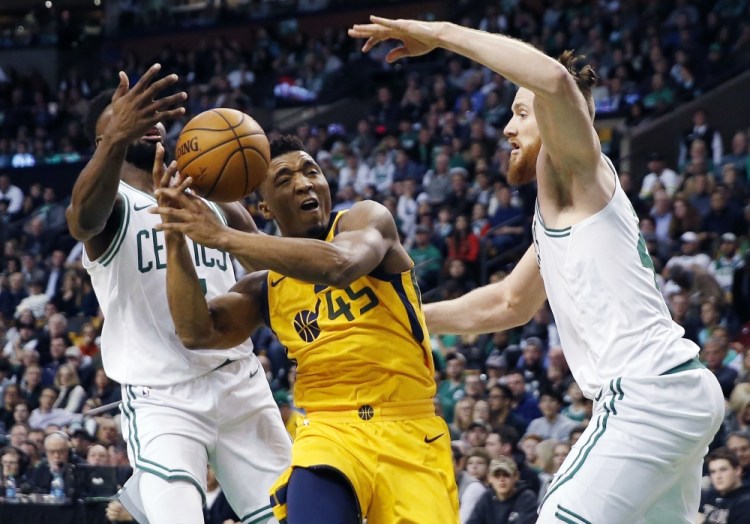 Utah's Donovan Mitchell drives for the basket between Boston's Jaylen Brown, left, and Aron Baynes in the second quarter Friday night in Boston.