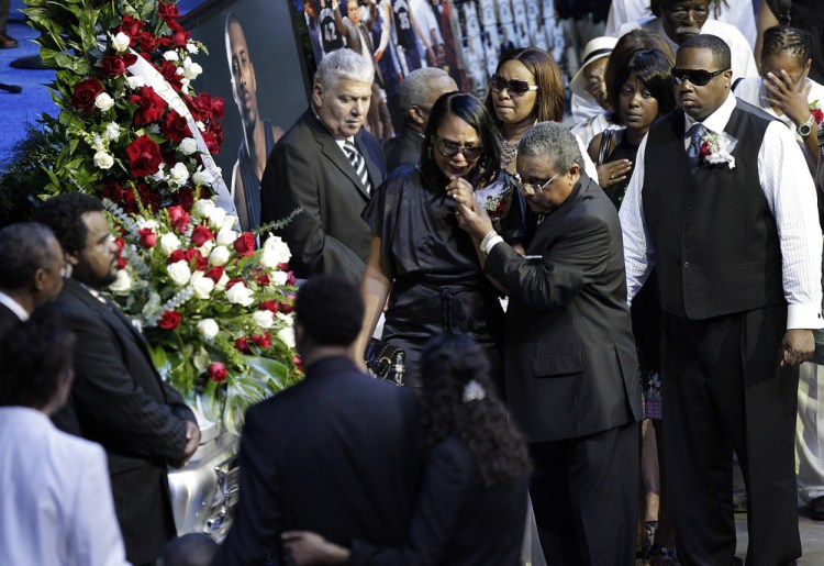 Sherra Wright, the ex-wife of slain NBA basketball player Lorenzen Wright, grieves at his casket during a memorial service at the FedExForum in Memphis, Tenn. Authorities said Saturday that she was charged with first-degree murder in his death.
