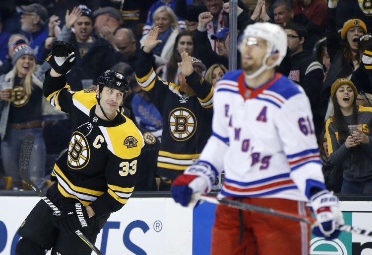Boston's Zdeno Chara, left, of Slovakia, celebrates the goal by teammate Danton Heinen behind as Rick Nash of the New York Rangers during Saturday's game in Boston. But the Rangers rallied in overtime for a 3-2 win.