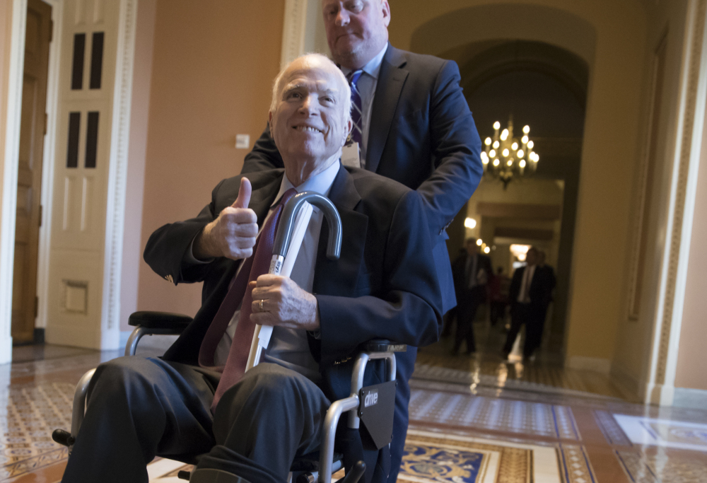 Sen. John McCain, R-Ariz., leaves a closed-door session where Republican senators met on the GOP effort to overhaul the tax code on Dec. 1. McCain is returning home to Arizona after being hospitalized over the side effects from his brain cancer treatment. The 81-year-old McCain has been hospitalized at Walter Reed Medical Center in Maryland.