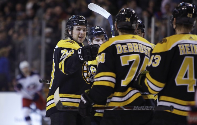 Bruins defenseman Charlie McAvoy smiles after scoring in the second period of what became a 7-2 rout over the Columbus Blue Jackets in Boston on Monday night. McAvoy later had the first fight of his NHL career.