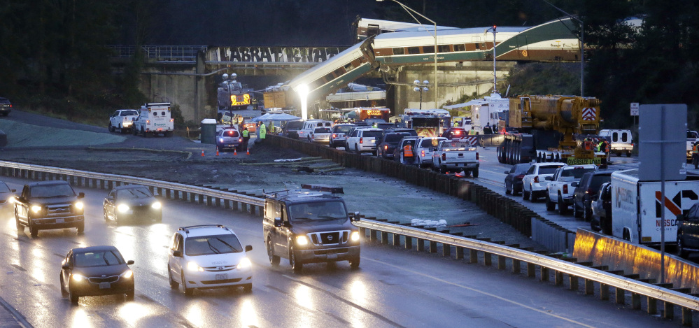 Traffic moves along northbound Interstate 5, left, as southbound lanes are filled with emergency vehicles near the scene of an Amtrak train crash Monday in DuPont, Wash.