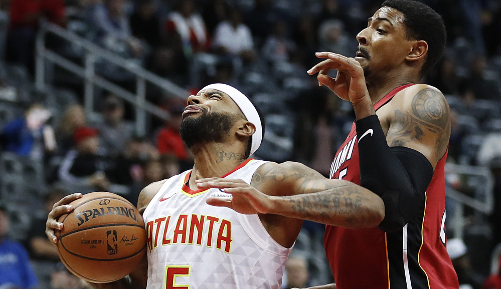 Atlanta's Malcolm Delaney, left, moves to the hoop while being guarded by Miami's Jordan Mickey in the Hawks' 110-104 win Monday in Atlanta.