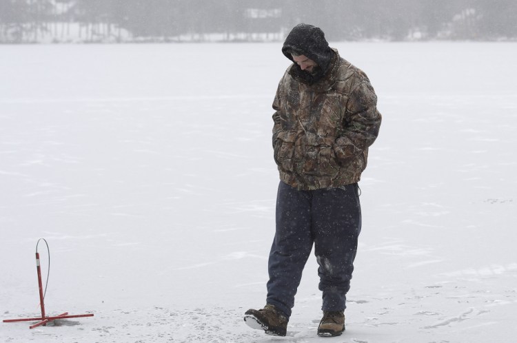 Billy Gayton of Leeds waits Monday for a flag while ice fishing on Cochnewagon Lake in Monmouth. Gayton measured 5 inches of ice along the shore, where he placed traps, and 3 inches about 100 yards out.