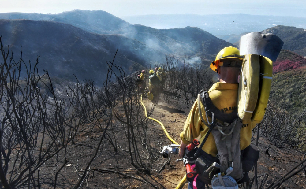 Mike Eliason/Santa Barbara County Fire Department via AP
Firefighters work along steep terrain to root out and extinguish smoldering hot spots in Santa Barbara, Calif., on Tuesday.