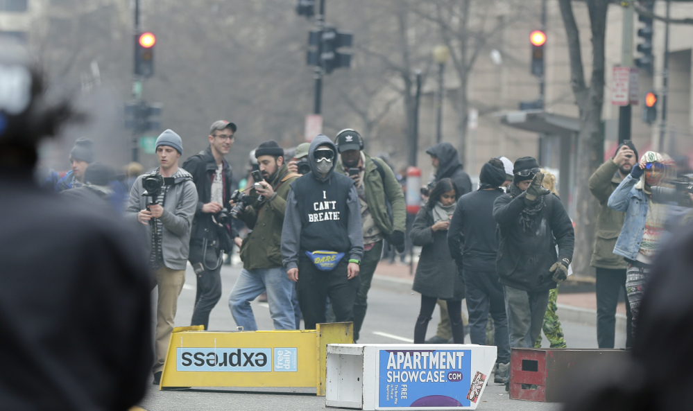 Protesters face off with police in downtown Washington on Inauguration Day. The first six people put on trial for violence at the protest were acquitted Thursday. Prosecutors told jurors there was no evidence the six were personally involved in the violence but argued that they chose to remain with the group, providing cover for the culprits. Left, the six included Brittne Lawson, center, Alexei Wood, left, and Oliver Harris.