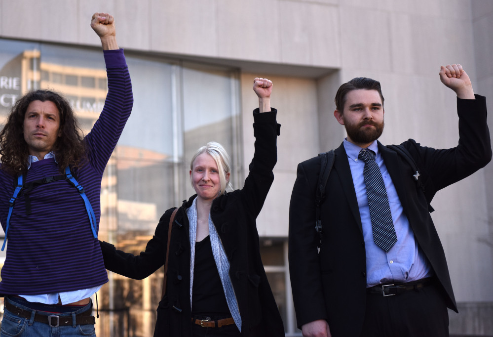 Brittne Lawson, center, Alexei Wood, left, and Oliver Harris raise their arms after receiving a not guilty verdict in the the first of the presidential inauguration riot trials on Dec. 21, 2017. 
 MUST CREDIT: Washington Post photo by Michael Robinson Chavez