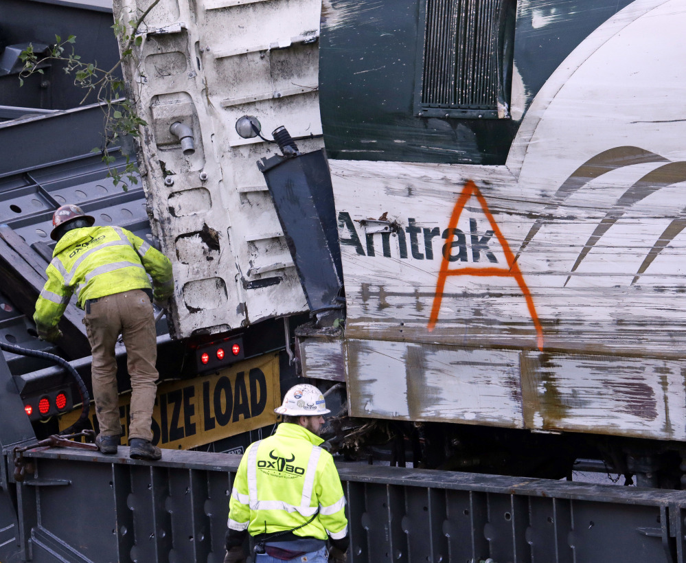 The engine from an Amtrak train that crashed in Dupont, Wash., on Monday is loaded onto a truck before being transported away from the scene.