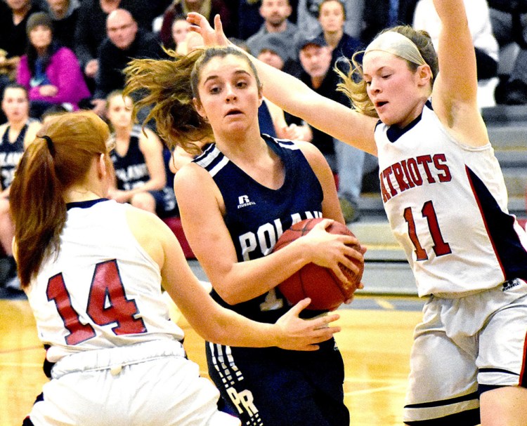 Poland's Nathalie Theriault drives between Eliza Hotham, left, and Alexa Thayer of Gray-New Gloucester during Thursday's game in Gray. Gray-New Gloucester won, 47-37,