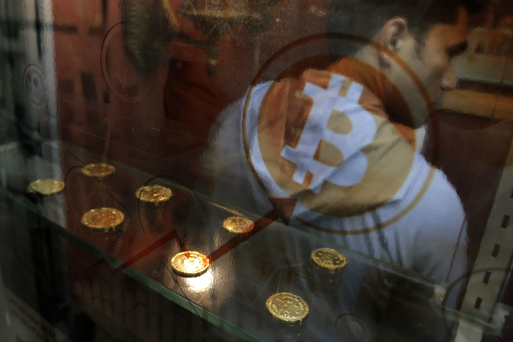 A man uses a Bitcoin ATM in Hong Kong. Bitcoin is the world's most popular virtual currency. The latest example of a company trying to tie its fortunes to the craze came Thursday in the form of an iced tea maker.