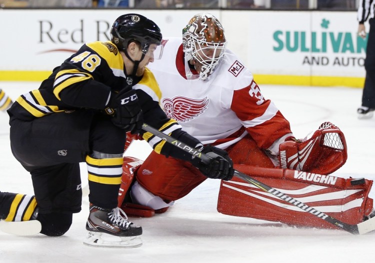 Detroit goalie Jimmy Howard, the former UMaine standout, blocks a shot by Boston's Matt Grzelcyk during the second period of Saturday's game in Boston. Howard made 23 saves, but the Bruins won, 3-1.