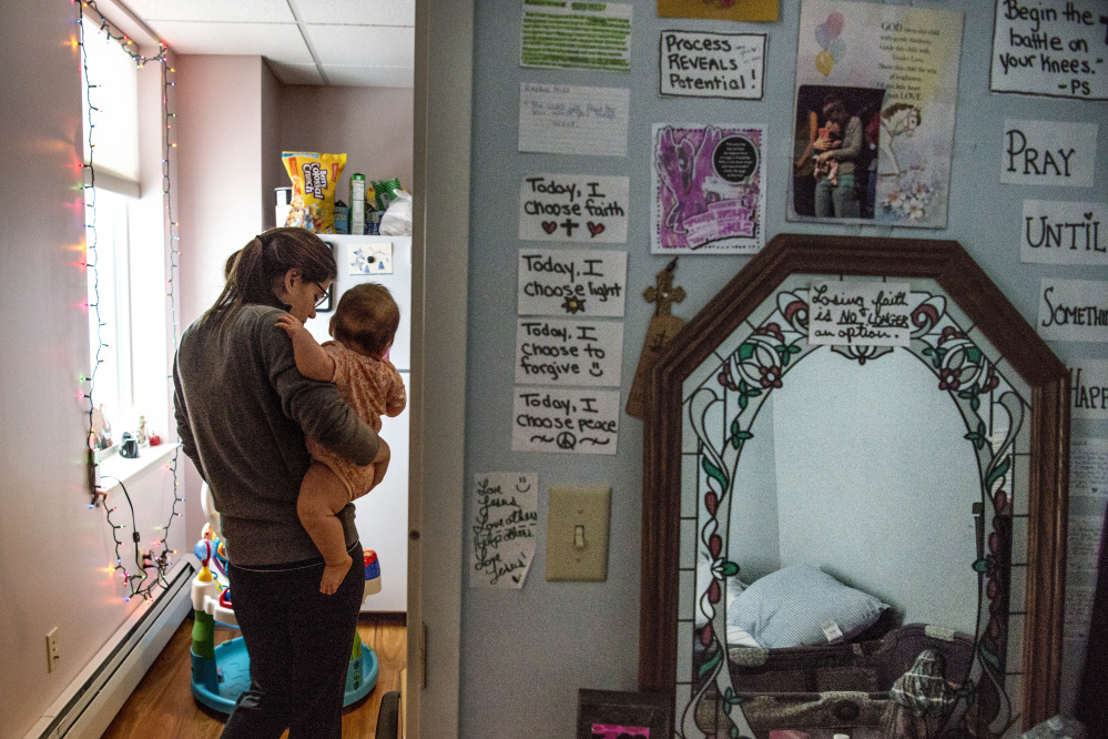 Kayla Clifton carries her 8-month-old daughter, Lilly, into the kitchen Friday after an afternoon nap at their transitional apartment at the Mid-Maine Homeless Shelter in Waterville.