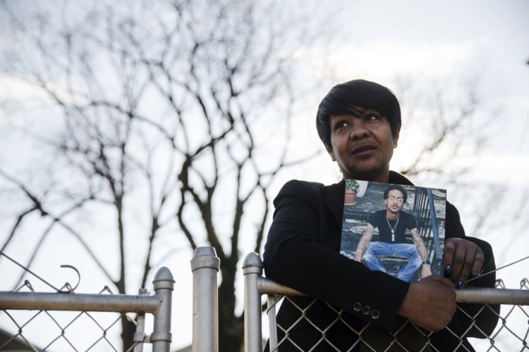 Trina Singleton poses Thursday in Collingdale, Pa., with a photograph of her eldest son, Darryl, who was murdered. Singleton says sharing Darryl's life story through The Philadelphia Obituary Project has helped the family move forward.