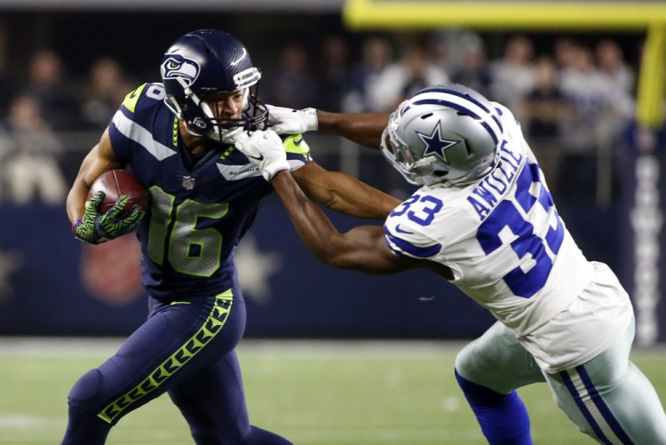 Seattle receiver Tyler Lockett has his facemask grabbed by Dallas cornerback Chidobe Awuzie after making a reception Sunday in the second half of Seattle's 21-12 victory.