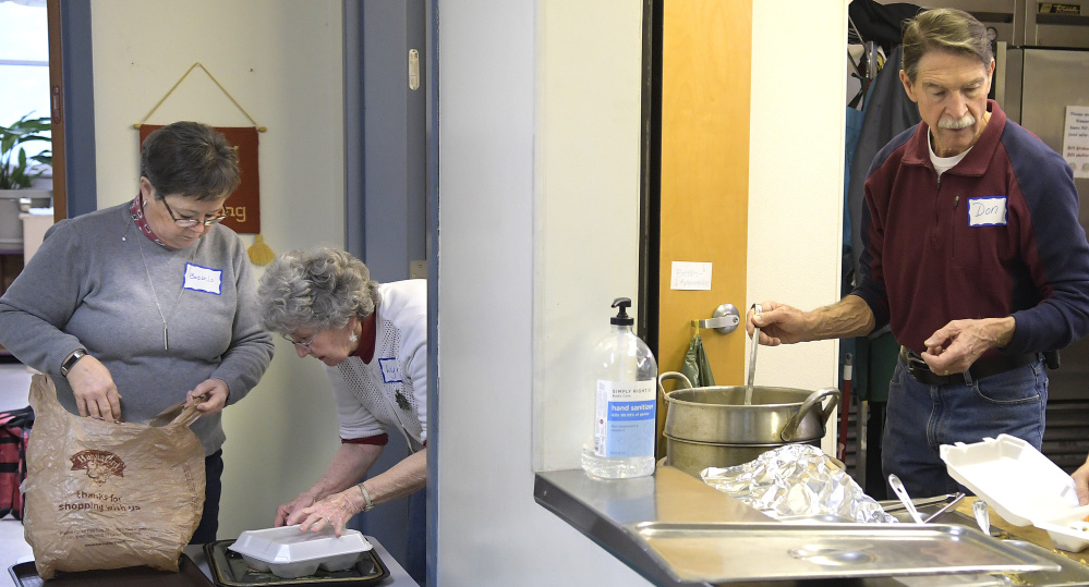 Volunteers prepare meals Monday at Emmanuel Lutheran Episcopal Church in Augusta. Over 250 meals were served by volunteers during whiteout conditions.