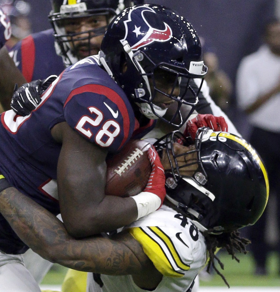Running back Alfred Blue of the Houston Texans is hit by Pittsburgh linebacker Bud Dupree during the first half.