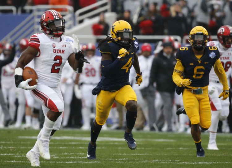 Zack Moss of Utah outruns the West Virginia secondary to the end zone to score Tuesday during the first half of Utah's 30-14 victory in the Heart of Dallas Bowl.