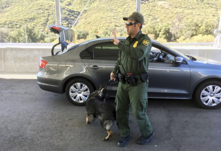 In this Thursday, Dec. 14, 2017 photo, a border patrol agent stops a vehicle at a checkpoint in Pine Valley, Calif. California legalizes marijuana for recreational use on Monday, Jan. 1, 2018, but that won't stop federal agents from seizing small amounts on busy freeways and backcountry highways. Marijuana possession will continue to be prohibited at eight Border Patrol checkpoints in California, a reminder that state and federal law collide when it comes to pot. (AP Photo/Elliot Spagat)