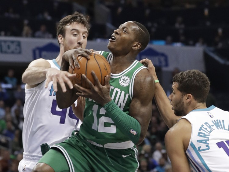 Boston's Terry Rozier is fouled as he drives between Charlotte's Frank Kaminsky, 44, and Michael Carter-Williams in the first half Wednesday night in Charlotte, N.C.