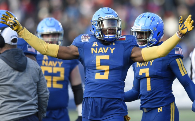 Navy's Justin Norton celebrates holding a fourth-down stop against Virginia in the first half of the Midshipmen's 49-7 rout in Military Bowl on Thursday in Annapolis, Md.