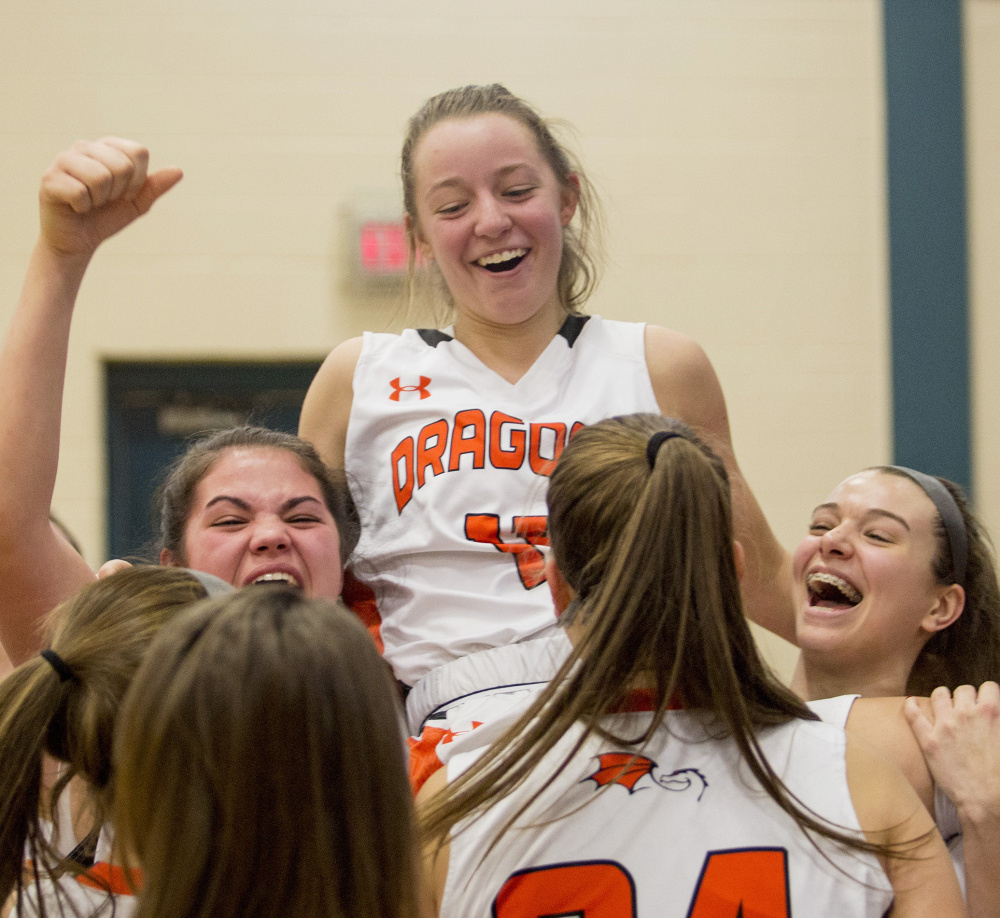 Junior point guard Marley Groat gets the hero's welcome from her teammates after hitting the winning shot, giving her 17 points for the game and lifting the Dragons to a 6-0 record.