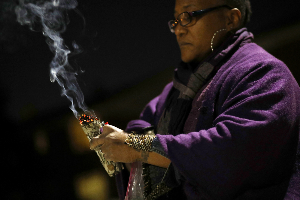 Erricka Bridgeford burns sage as she performs a ceremony near the scene of a homicide in Baltimore. Bridgeford lost a brother, a stepson, and three cousins to gun violence.