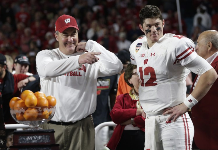 Wisconsin coach Paul Chryst and quarterback Alex Hornibrook stand next to the MVP trophy at the end of the Orange Bowl game against Miami on Saturday night in Miami Gardens, Fla. Hornibrook won the MVP trophy and Wisconsin defeated Miami 34-24.